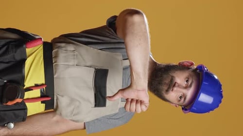 Vertical Video Portrait of Construction Worker Giving Thumbs Down in Studio