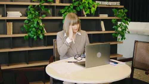 Woman Works at Laptop, Takes off Glasses