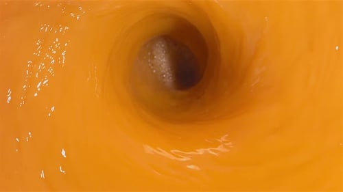 Peaches Splashing into Orange Juice Whirlpool