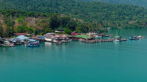 Quaint Seaside Fishing Village with Docked Boats and Lush Hills