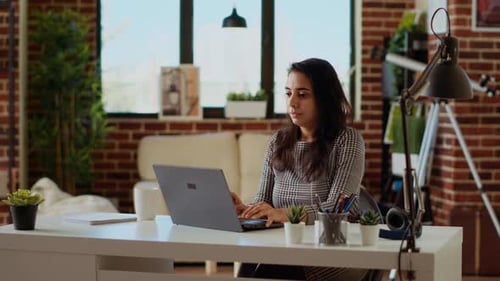 Self Employed Woman Sitting at Computer Desk Typing on Laptop Keyboard