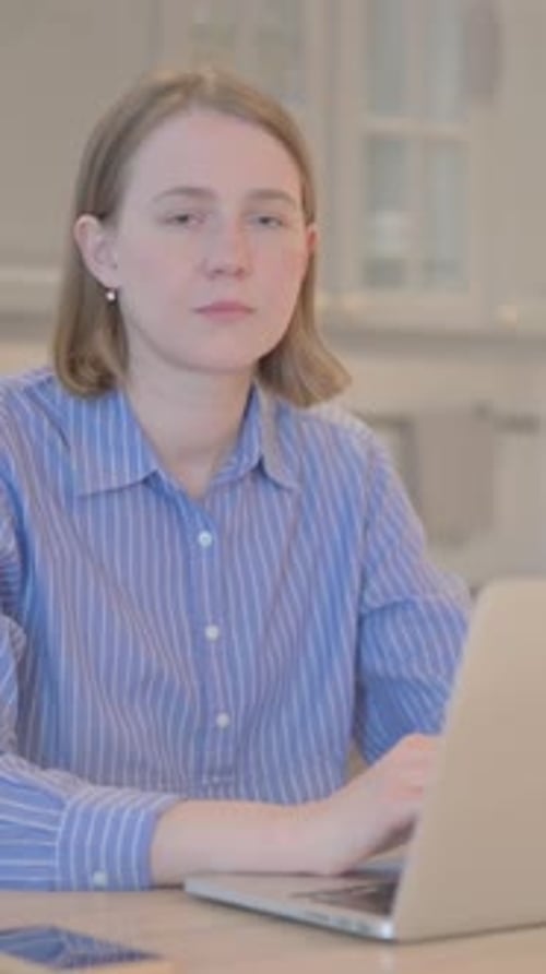Woman Smiling at Laptop in Home Interior