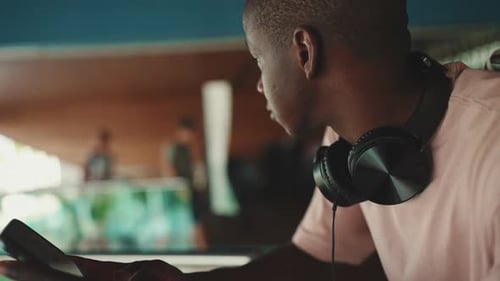 Glousez, un jeune homme au casque utilise un téléphone portable et regarde autour de lui