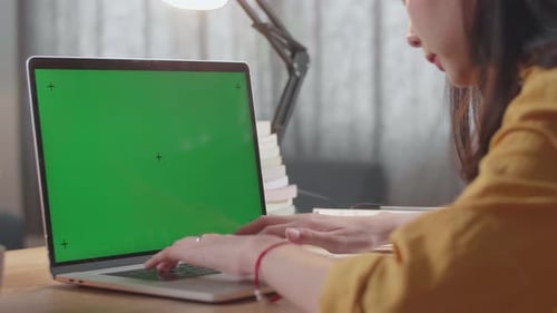 Close Up Of A Mock Up Green Screen Laptop Being Typed By A Female While Studying At Home
