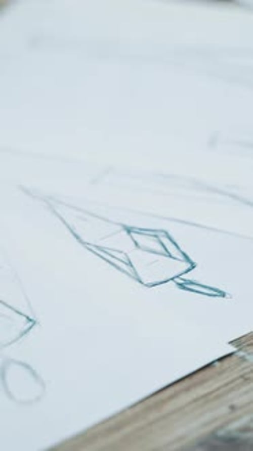 White sheets of papers with stylish sketches painted on the table.