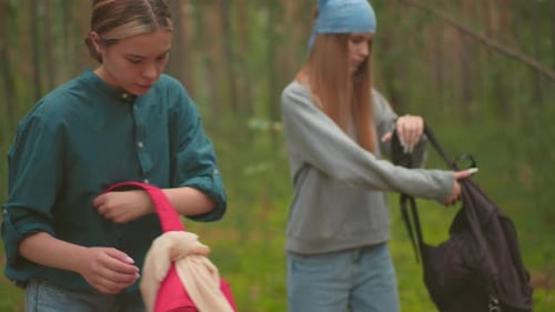 Siblings Walking Through Peaceful Forest and Pausing to Open Backpacks