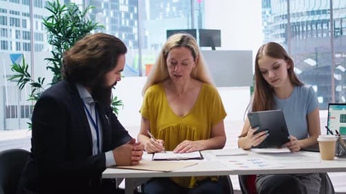 Business Professionals Sign Agreement in Modern Office