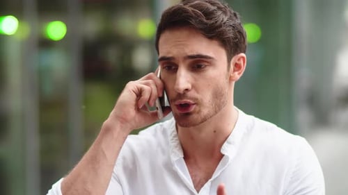 Angry businessman talking on smartphone in city street close up slow motion