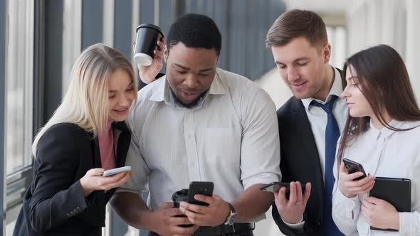 Smiling Colleagues Sharing Phones in Modern Office, Business, Corporate ...