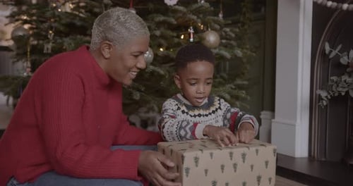 Woman and Child Opening Christmas Gift Together