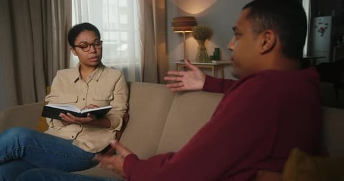 Une thérapeute à l'expression attentive écoute l'homme