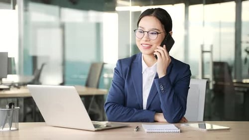 Smiling Woman Talking on Phone in Office