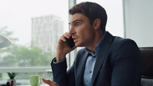 Furious businessman shouting on phone discussing problems in office workplace