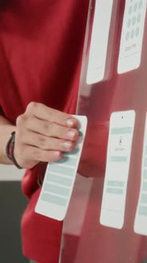 Woman Designs Mobile App Interface on Glass Board