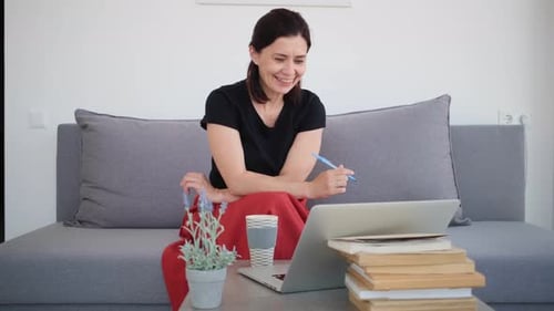 Smiling Woman Video Conferencing At Home on Laptop