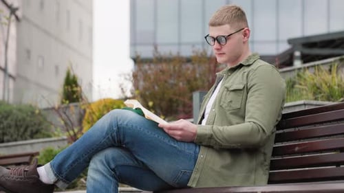 Männlicher Bücherwurm genießt die Natur beim Lesen