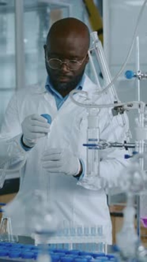 Lab Technician Filling Test Tube with Liquid using Bulb Pipette