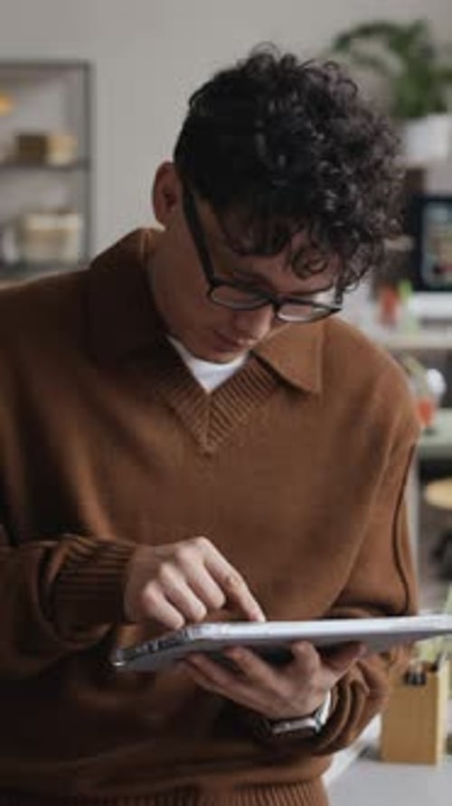Asian Employee Using Digital Tablet at Modern Office Workplace