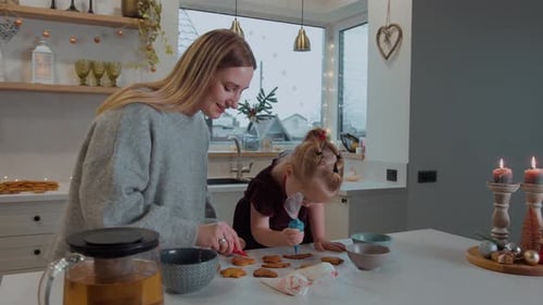 Mother and Daughter Decorate Gingerbread Cookies for Christmas