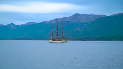 Tall Ship Sailing on Calm Water Near Mountains and Forested Hills in Ushuaia Argentina Aerial Drone