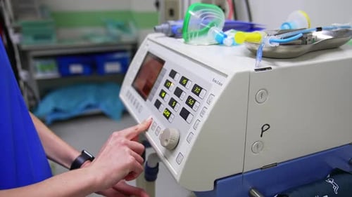 Female hand pressing the buttons on the equipment in surgery room. Close up.
