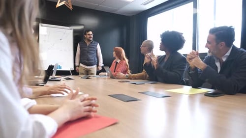 Businessman Discussing with Colleague During Presentation in Conference Room