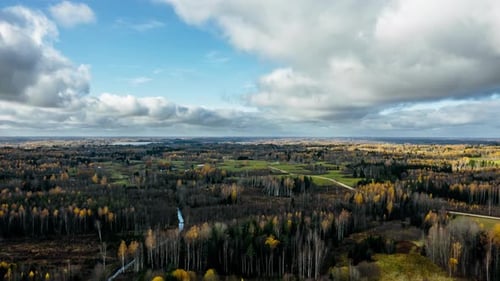Aerial drone hyperlapse over verdant countryside landscape in autumn covering vast area of land and