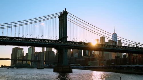 Manhattan Bridge and One World Trade Center at sunset flare.