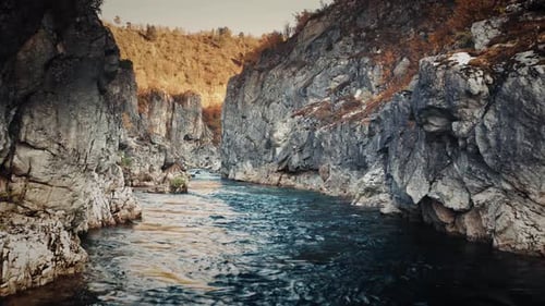 Vue aérienne de la rivière de montagne qui coule lentement dans le canyon profond et étroit. Forêt d'automne lumineuse