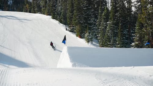 A skier spins and flips over a big jump in Big Sky Montana