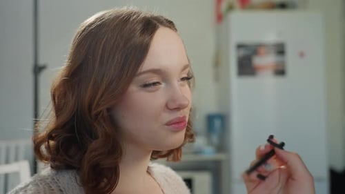 Kaukasische Frau wird mit präziser Lippenstiftapplikation gestylt Entspannte Frau empfängt Expertin