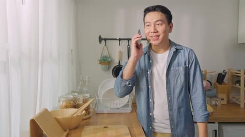 Smiling Man Talking on Phone in Bright Kitchen