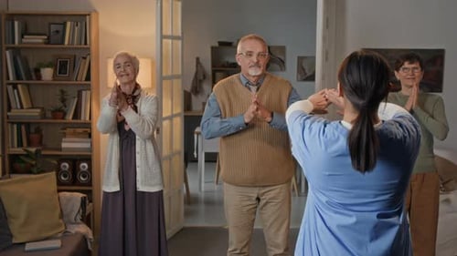 Seniors Exercising with Young Adult Instructor at Home