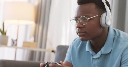 Young Adult Concentrated While Gaming at Home