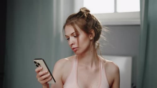 Woman Using Phone and Putting In Earbuds
