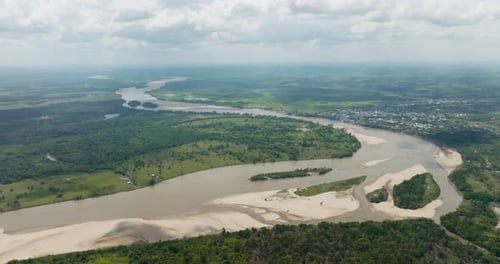 Florencia, colombia's winding river and lush landscape under a cloudy sky, aerial view