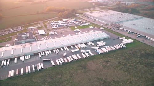 Aerial shot on a logistics park with a warehouse - a loading hub. Semi-trailers stand on ramps for l