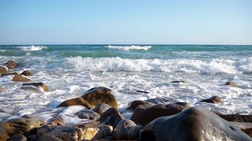 Sea waves splashing on the rocks of the beach shore. Summer vibes, travel, vacation, holiday. Waves