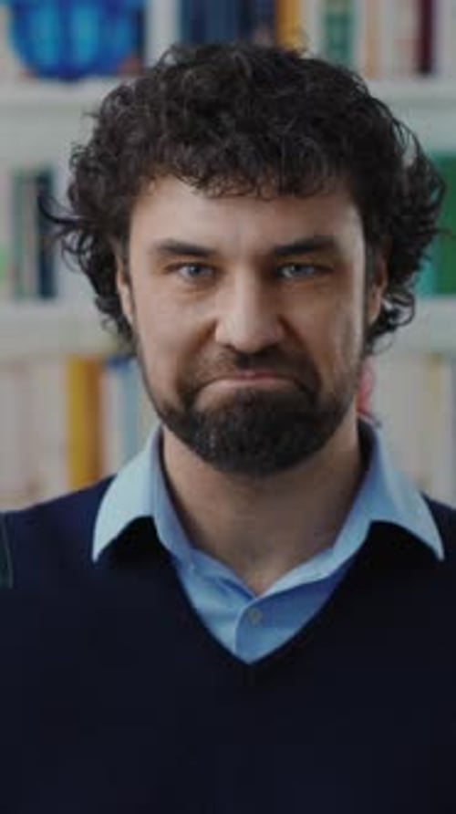 A Thoughtful Man Sporting Curly Hair Immersed in a Cozy Library Ambiance Setting