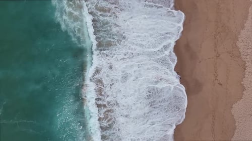 Stunning Aerial View of Beautiful Beach Waves Lapping Against the Sandy Shoreline