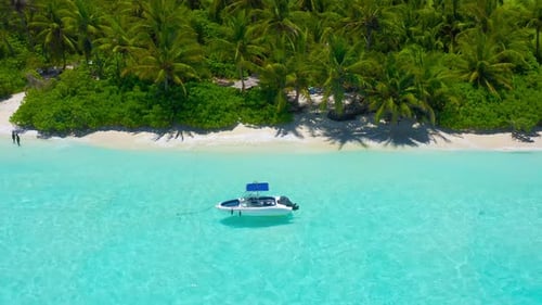 Aerial view of tropical island beach holiday tourist speed boat on blue reef ocean in Maldives