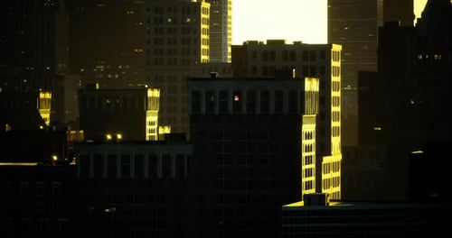 City Skyline Illuminated By Sunset with Warm Glow Reflecting Off Buildings