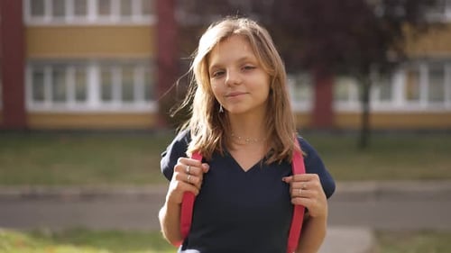 Portrait of Happy Girl in a Front of the School