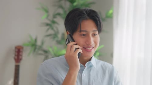 Young Adult Talking on Phone Indoors