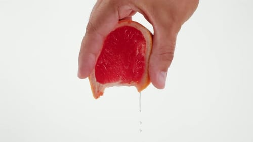 Hand Squeezing Fresh Grapefruit Close Up