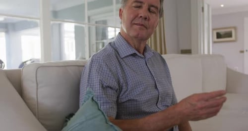 Contemplative Man Resting On Sofa Indoors