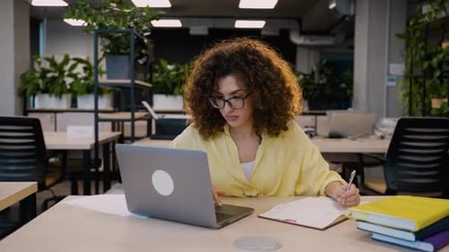 Young Businesswoman Working on Laptop in Modern Coworking Office
