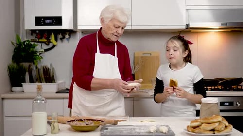 Little Girl Apetitically Eats Just Baked Pie with Filling Loving Grandmother Teach Granddaughter