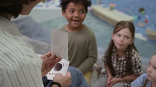Tutor Using Letter Cards when Talking to Group of Diverse Kids
