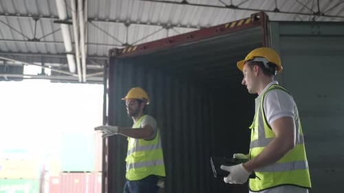 Blue collar workers are working at warehouse.